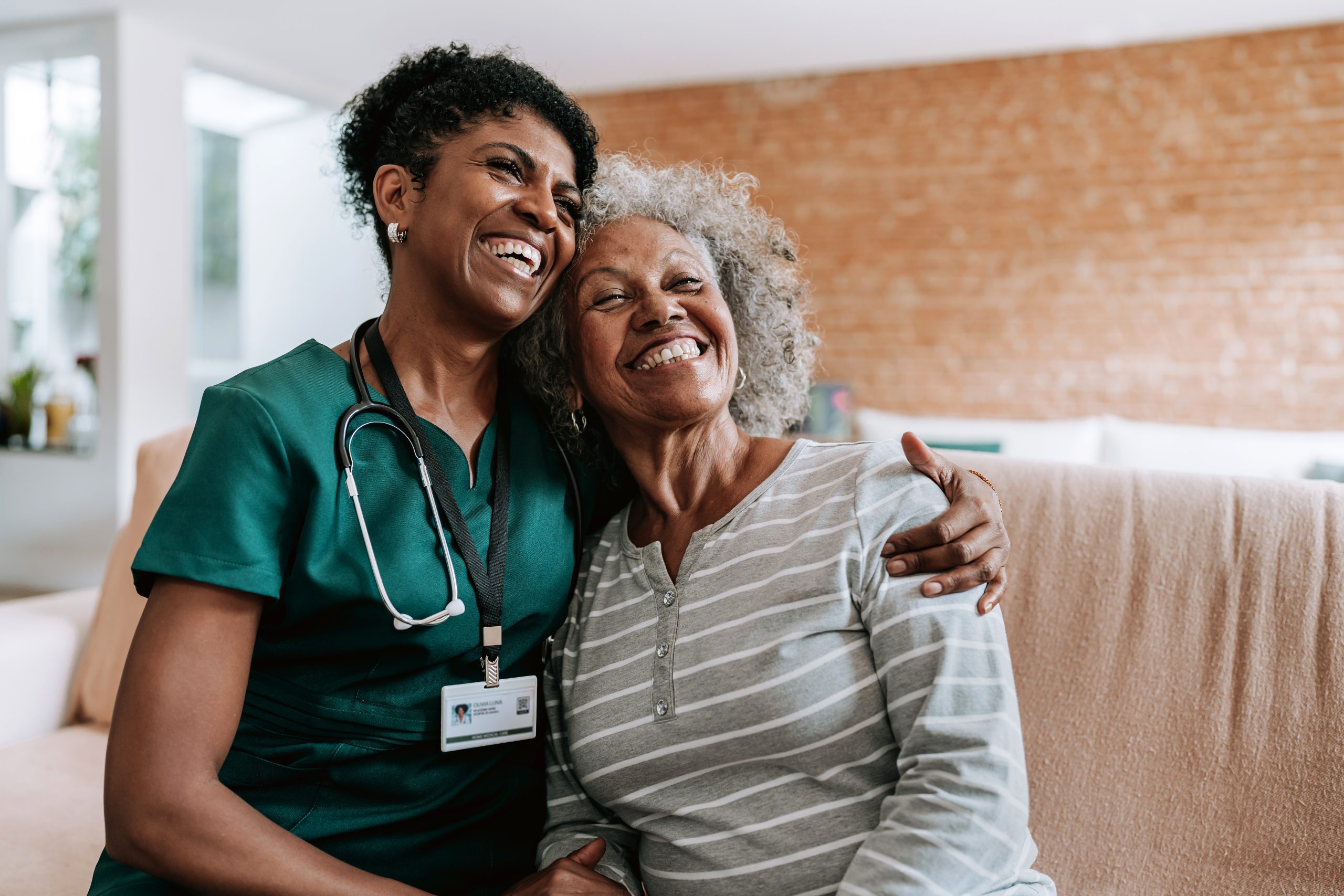 Home care healthcare professional hugging elderly patien